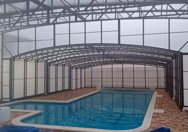 Раздвижной павильон на рельсах из гнутых стальных ферм для широких и общественных бассейнов